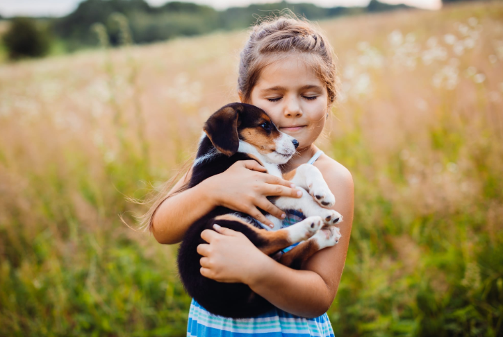 little girl carrying a puppy